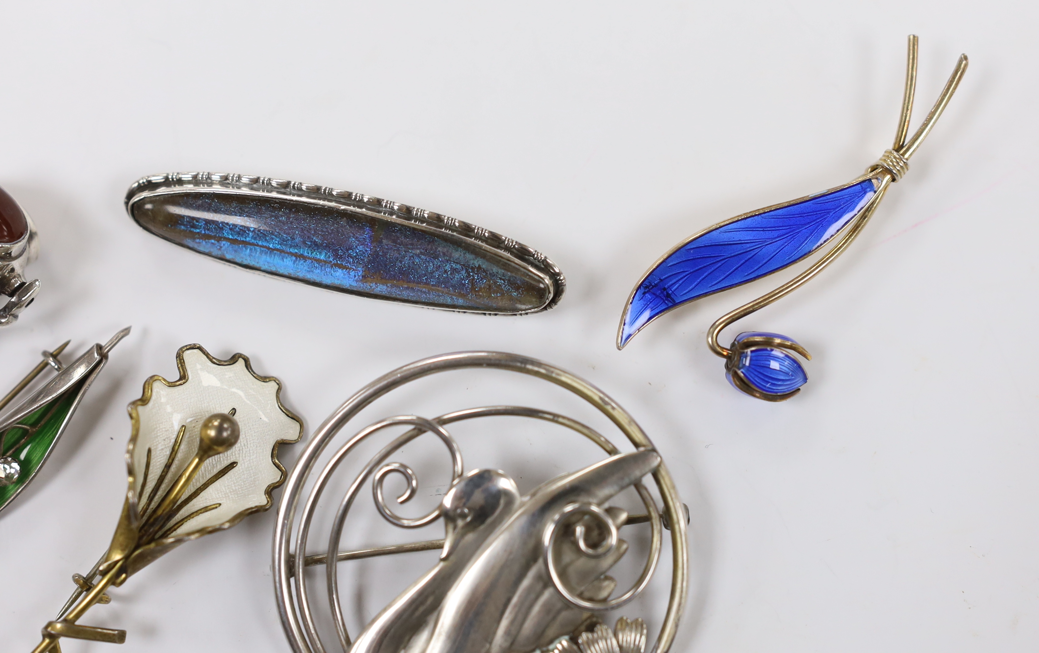 Two Norwegian sterling and enamel foliate spray brooches, largest 60mm, two sterling brooches including circular swan brooch, a modern silver, paste and enamel set leaf brooch and a modern silver and gem set spinning fob